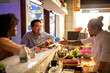© Marko Geber - Friends chatting with sushi chef at restaurant counter