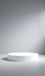 © fuwen - A round white pedestal stands on a grey surface.