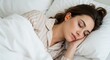 © rdkcho - Serene Young Woman Sleeping Peacefully in Bed with Earplugs, Wearing Pajamas