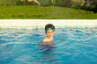 © dargog - Child wearing swimming goggles swim in a pool on a sunny day enjoying water fun and leisure