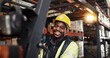© peopleimages.com - Warehouse, logistics and black man in portrait with forklift, supply chain or shipping for distribution. Factory, male person and worker with machine for driving, delivery or manufacturing with smile