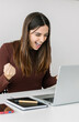 © Xavier Lorenzo - Young happy business woman celebrating online success looking at laptop screen.