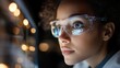 © Babycrab - Close up portrait of a young woman wearing clear safety goggles and lab coat, looking at a screen in a dark environment with bokeh lights in the background