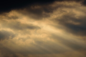 Wall Mural - dark dramatic sky at sunset with sun rays through the clouds