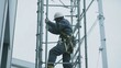 © LorelEino - A laborer setting up scaffolding at a work site. Featuring teamwork and safety