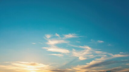 the sky is blue and clear with a few clouds scattered throughout. the sun is setting, casting a warm