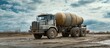 © Almahyra - Cement mixer truck on muddy construction site under cloudy sky
