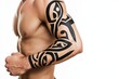 © Nico - Tribal Armband A bold tribal armband tattoo featuring intricate black patterns that wrap around the upper bicep.