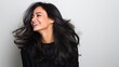 © Georgy - In a closeup portrait, a gorgeous young Asian Indian female model is seen shaking her beautiful hair, as seen in an advertisement for shampoo, conditioner, and other hair products, set against a