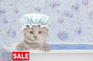 Fototapete - Cute kitten wearing shower cap takes the bath at home and  shows signboard with labeled 