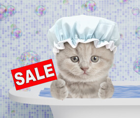 Fototapete - Cute kitten wearing shower cap takes the bath at home shows thumbs up gesture and signboard with labeled 