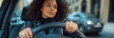 confident woman driving car with hands on steering wheel in urban city street