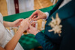 © Raivo - Close-up of groom placing a wedding ring on the bride’s finger during the ceremony, symbolizing love, unity, and commitment..
