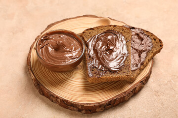 Wall Mural - wooden board of toasts with sweet chocolate spread on beige background