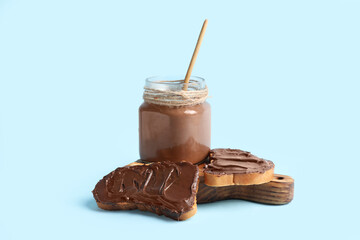 Wall Mural - bread slices with sweet chocolate spread on blue background