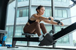 © 2B - Rowing workout session in a modern gym with large windows showcasing natural light