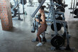 © 2B - Fitness enthusiast performs strength training at a well-equipped gym during daytime