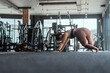 © 2B - Woman practicing yoga in a fitness studio during a morning workout session, focusing on forward bend position for flexibility