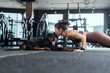 © 2B - Woman doing push-ups with her Rottweiler dog in a modern gym during daylight