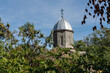 © SergioDenisenko - Orthodox Church is Church of Iverskaya Our Lady or Armenian Church as Church of John Baptist. Church dome with cross atop, surrounded by lush greenery and  clear blue sky.