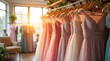 © Konstantin - Collection of evening dresses hanging on a hanger in the sunlight in a fashion store