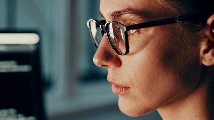 Aufkleber - Female programmer wearing glasses concentrating on source code. Working late at night in dimly lit office. Analyzing complex data on computer monitor with intense focus and professional determination
