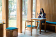 © Parichat - Asian student using mobile phone app sitting in a modern cafe enjoying break studying using technology