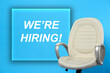 © New Africa - We're hiring. Empty office chair on light blue background. Recruitment concept