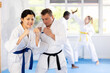 © JackF - Sportive middle-aged woman trainee of karate courses applying attack methods on her partner