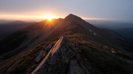 Aufkleber - Striking aerial view of a rugged mountain peak at sunrise. The sunburst adds a focal point, accentuating the rough terrain and the natural beauty of the mountain landscape. The scene is bathed in