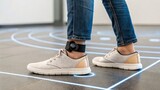 Healthcare Technology Medical Devices Innovation concept, Person wearing sneakers with an ankle monitor, walking on a patterned floor.