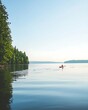 © Atthapon - A man in a red kayak is paddling on a lake