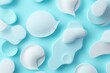 © Splash - Close up shot of white cream blobs on a light blue background with soft lighting and a smooth texture
