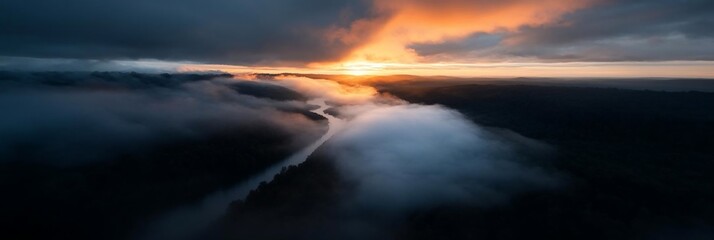 Aufkleber - Aerial view of a river cutting through a forest shrouded in mist during sunset creating a mystical scene illuminated by golden light
