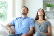 © Antonioguillem - Couple relaxing at home breathing fresh air on a sofa