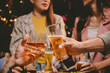 © Witoon - Happy group of friends toast with draft beer at a lively pub, celebrating friendship, fun, and festive moments together indoors.