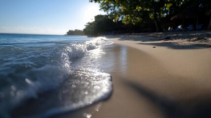 Aufkleber - Close-up of foamy wave washing onto sandy beach on a sunny day with bright light. Soft focus and blurred background create a sense of tranquility and peace