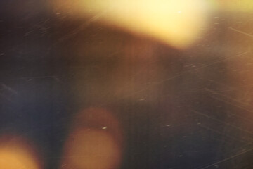 Wall Mural - grainy colorful warm orange light leaks on black background with dust texture. abstract damaged scra