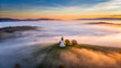 © saichon - serene church stands alone on hill, surrounded by blanket of fog at sunrise, creating peaceful and mystical atmosphere