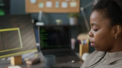 Wall Mural - tilt up shot of young concentrated black female software engineer typing program code while working 
