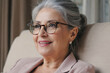 © Luna - A woman wearing glasses sits comfortably in a chair, possibly reading or working