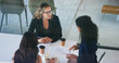 © peopleimages.com - Business people, conversation and women in office, above and feedback for financial report. Employees, advice and mentor in workplace, cooperation and meeting for project development and planning