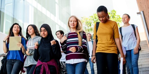 Fototapete - Diverse group of students walking down stairs. Young adults, casual attire. Students chatting, holding books, backpacks. Group of students outdoors. Diverse students hanging out after school.
