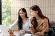 © Natee Meepian - Collaborative Study and Learning. Two friends engaged in a study session, sharing ideas over a laptop.
