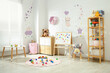 © New Africa - Cozy playroom with toys, furniture and cute wallpaper. Stylish children's room interior