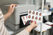 © New Africa - Worker with passport photos of women near modern printer indoors, closeup