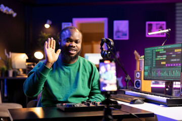 Leinwandbilder - Skilled audio engineer teaching online mixing tunes lessons by using a smartphone on tripod to record himself in home studio. Producer hosting a master class with soundboard console gear.
