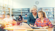 © JackF - Friendly female teacher helps schoolgirl find information in laptop in the school library