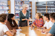 © JackF - Portrait of adult female librarian and diligent schoolkids during classes in school library