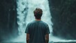 © Egriva - Man contemplates majestic waterfall, lush jungle backdrop; travel, serenity